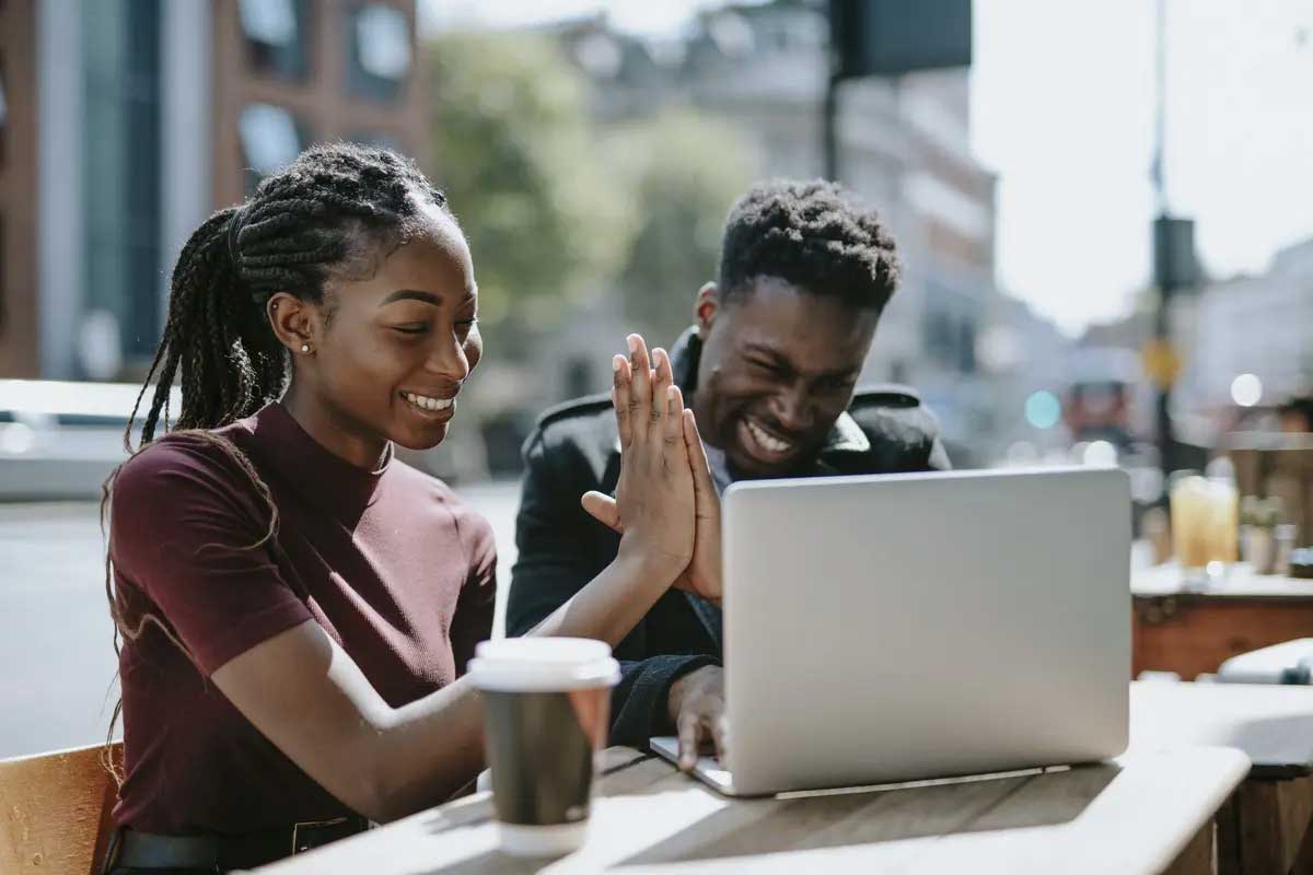 Two people working on laptop and drinking coffee